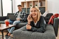 Young caucasian couple smiling happy using laptop and talking on the smartphone at home Royalty Free Stock Photo