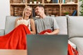 Young caucasian couple smiling happy watching movie eating popcorn at home Royalty Free Stock Photo