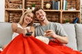 Young caucasian couple smiling happy watching movie eating popcorn at home Royalty Free Stock Photo