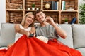 Young caucasian couple smiling happy watching movie eating popcorn at home Royalty Free Stock Photo
