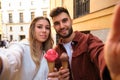 Young Caucasian couple taking a selfie while eating an ice cream. Royalty Free Stock Photo