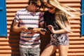 Young caucasian couple use modern cellular phone device together sharing contents with app and technology - outdoor people in Royalty Free Stock Photo