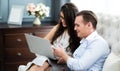 Young caucasian couple using laptop computer at home..shopping online at home. couple planning a trip abroad on their wedding