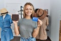 Young caucasian customer woman holding leather purse and credit card at clothing store Royalty Free Stock Photo