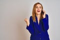 Young caucasian elegant business woman talking on the phone over isolated background screaming proud and celebrating victory and Royalty Free Stock Photo