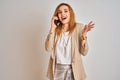 Young caucasian elegant business woman talking on the phone over isolated background very happy and excited, winner expression Royalty Free Stock Photo