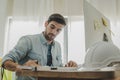 Young caucasian engineer, architect, contractor thinking working about new project contract plan with computer and white safety he Royalty Free Stock Photo