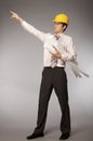 Young caucasian engineer with plans pointing finger away Royalty Free Stock Photo