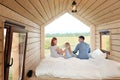 Young Caucasian family couple with baby daughter in a small modern rustic house with a large window. Lying on the bed Royalty Free Stock Photo