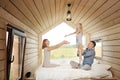 Young Caucasian family couple with baby daughter in a small modern rustic house with a large window. Lying on the bed Royalty Free Stock Photo