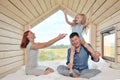 Young Caucasian family couple with baby daughter in a small modern rustic house with a large window. Lying on the bed Royalty Free Stock Photo