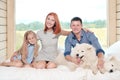 Young Caucasian family couple with baby daughter in a small modern rustic house with a large window. Lying on the bed Royalty Free Stock Photo