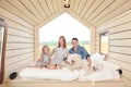 Young Caucasian family couple with baby daughter in a small modern rustic house with a large window. Lying on the bed Royalty Free Stock Photo