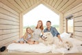 Young Caucasian family couple with baby daughter in a small modern rustic house with a large window. Lying on the bed Royalty Free Stock Photo