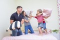 Young Caucasian Family Having a Playful Funny Pillow Fight Indoors Royalty Free Stock Photo