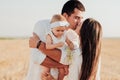 Young Caucasian Family with Toddler Child Hugging Outdoors in the Field, Mother and Father Kissing While Their Daughter Royalty Free Stock Photo