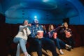 Young caucasian family watching a film at a movie theater