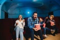 Young caucasian family watching a film at a movie theater