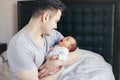 Caucasian father dad with newborn mixed race Asian Chinese yawning baby. Man parent holding child