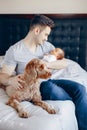 young Caucasian father with mixed race Asian Chinese newborn baby. Dog pet lying on bed. Royalty Free Stock Photo