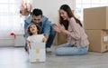 Young Caucasian father playing with little daughter that sitting inside cardboard box while unpacking move to new house Royalty Free Stock Photo