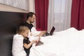 Young caucasian father should work from home as isolated at quarantine, kid is near with tablet,