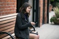 Woman Waiting for a Bus or Train While Sitting on a Bench Royalty Free Stock Photo