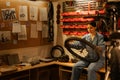 young caucasian female cycling mechanic checking bicycle wheel in workshop or garage. Bike service, repair and upgrade Royalty Free Stock Photo