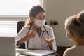 Caucasian female doctor consult old patient in facemask Royalty Free Stock Photo