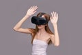 Young caucasian female engaging with virtual reality using vr headset on gray Royalty Free Stock Photo