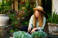 Young caucasian female gardener planting vegetables smiling happily. Junior cheerful woman with trowel sitting in her