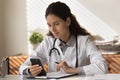 Female doctor work in clinic using modern cellphone