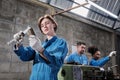 Professional young female worker with team in metalwork manufacturing factory