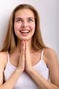 Young caucasian female keeping hands together, praying or begging, smiling happily Royalty Free Stock Photo