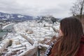 Young Caucasian female looking at a beautiful cityscape covered in snow