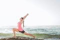 Young caucasian female practicing yoga on the seaside Royalty Free Stock Photo