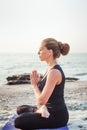 Young caucasian female practicing yoga on the seaside Royalty Free Stock Photo