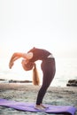 Young caucasian female practicing yoga on the seaside Royalty Free Stock Photo