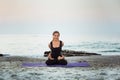 Young caucasian female practicing yoga on the seaside Royalty Free Stock Photo