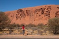 Young Caucasian female taking photos of Ayers rocks at Uluru-Kata Tjuta National Park