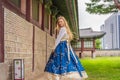 Young caucasian female tourist in hanbok national korean dress at Gyeongbokgung Palace. Travel to Korea concept Royalty Free Stock Photo