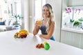 Young caucasian fitness woman wearing sportswear drinking healthy orange juice looking positive and happy standing and smiling Royalty Free Stock Photo