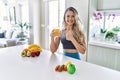 Young caucasian fitness woman wearing sportswear drinking healthy orange juice smiling happy and positive, thumb up doing Royalty Free Stock Photo