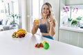 Young caucasian fitness woman wearing sportswear drinking healthy orange juice surprised with an idea or question pointing finger Royalty Free Stock Photo