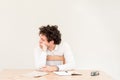 Young, Caucasian freelancer man sitting in his home office at the table in front of empty clear wall. Royalty Free Stock Photo