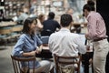 Young caucasian freelancers having business meeting at public place, working in cafe