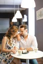 Young caucasian girl and boy sitting at cafe, drinking coffee and resting. Royalty Free Stock Photo