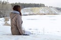 A young Caucasian girl in a brown coat staring into the distance on the horizon line Royalty Free Stock Photo