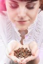 Young Caucasian Girl Holding Heap of Unbroken Coffee Beans and B