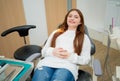 Young Caucasian girl lie on dental chair and smile to camera. Concept of happiness to treat teeth of patient Royalty Free Stock Photo